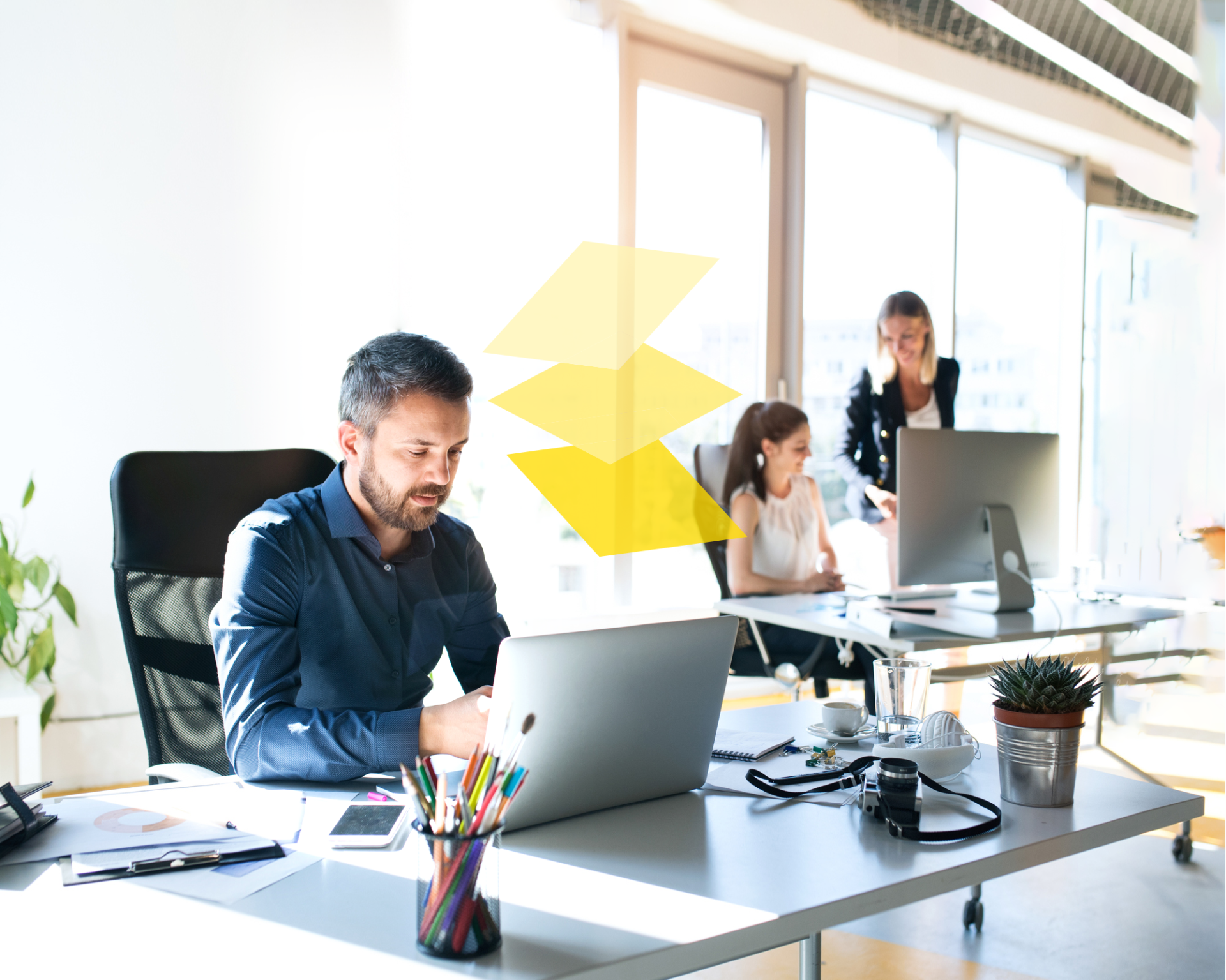 Chef d'entreprise à son bureau devant l'ordinateur qui gère ses documents sur le cloud.