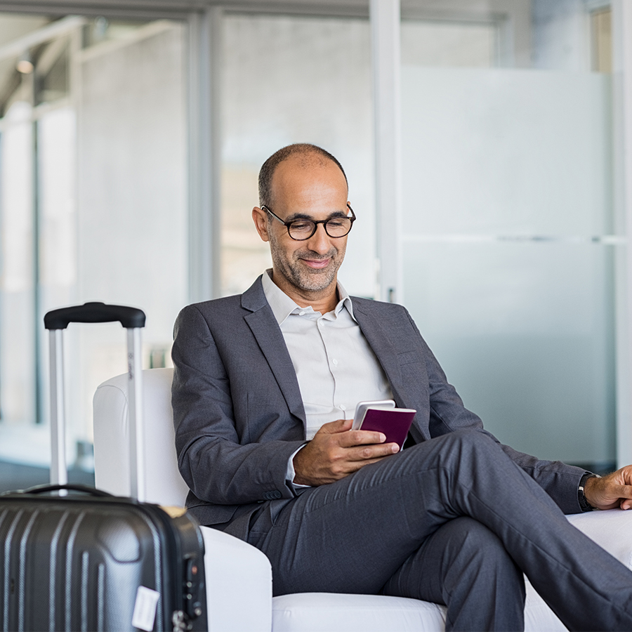 Homme d'affaire en train de voyager qui utilise son téléphone et la technologie centrex
