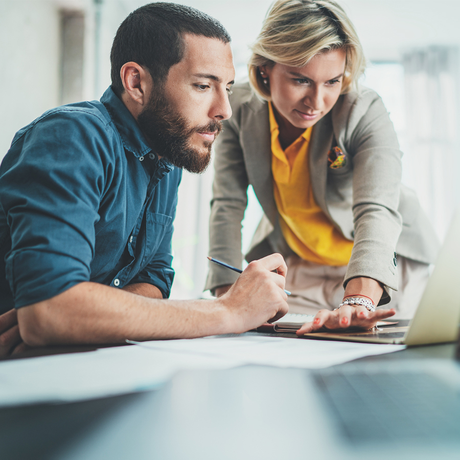 Photo d'un homme en train d'être accompagné par une professionnelle dans son domaine des solutions digitales