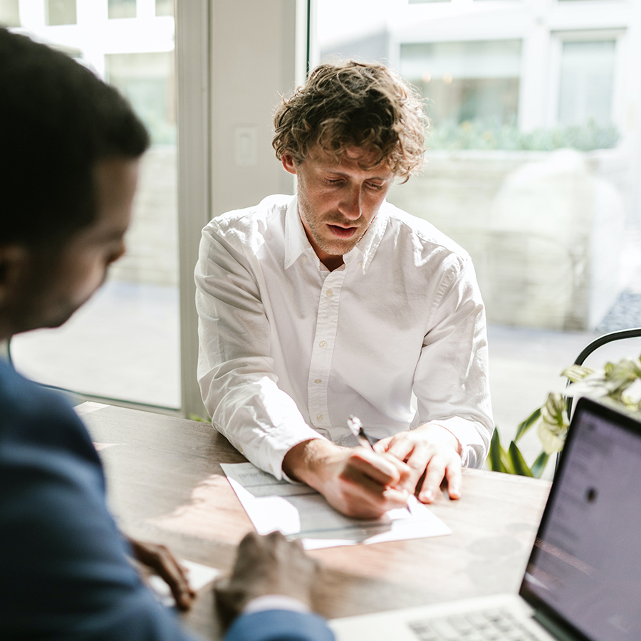 un homme en train de signer un document tout en étant accompagné par un expert Axens