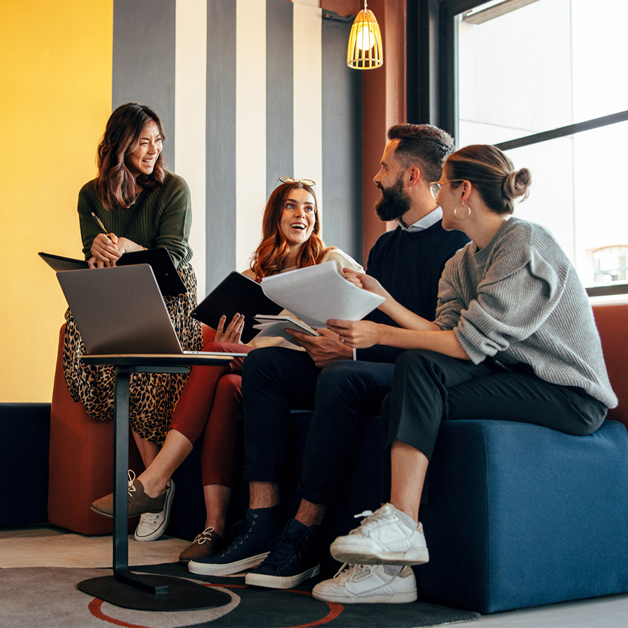 Réunion de travail avec des ordinateurs et des documents en utilisant la dématérialisation.